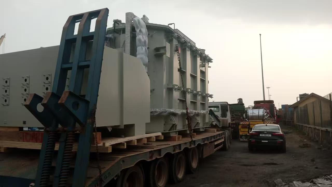 Precise crane lifting and positioning of out-of-gauge power generation equipment at port for break bulk shipping.