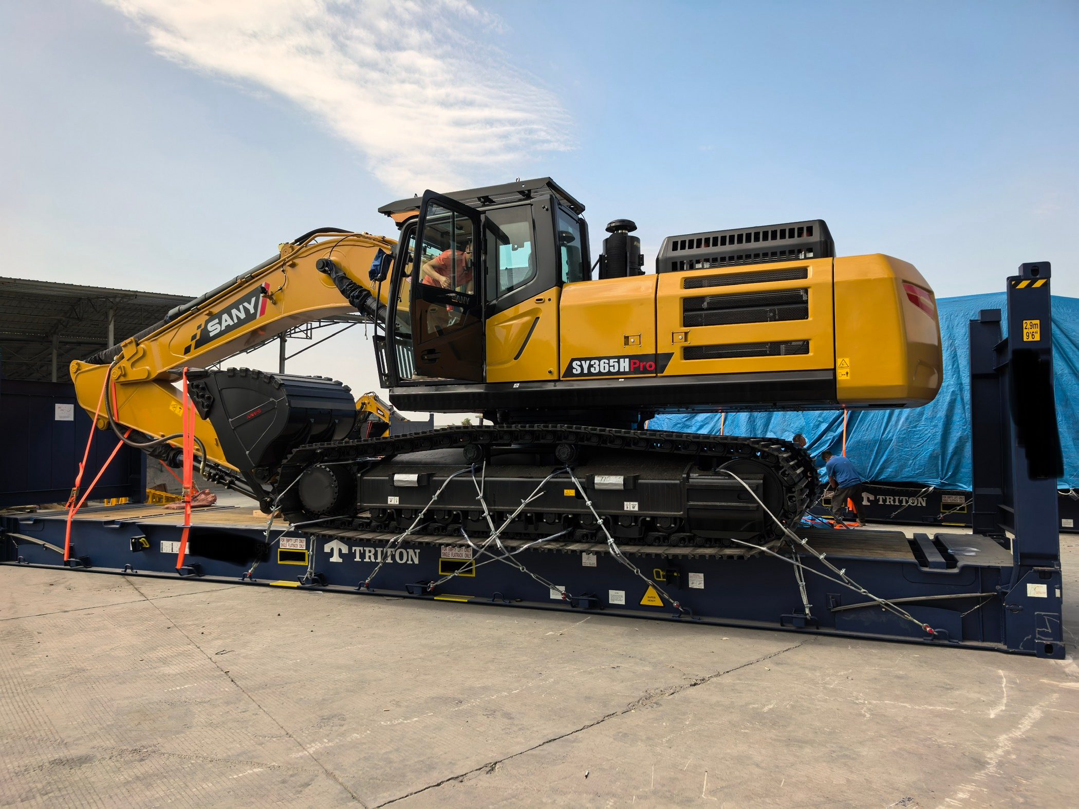 Mining excavator on lowboy trailer staged for Ro-Ro shipment to Africa