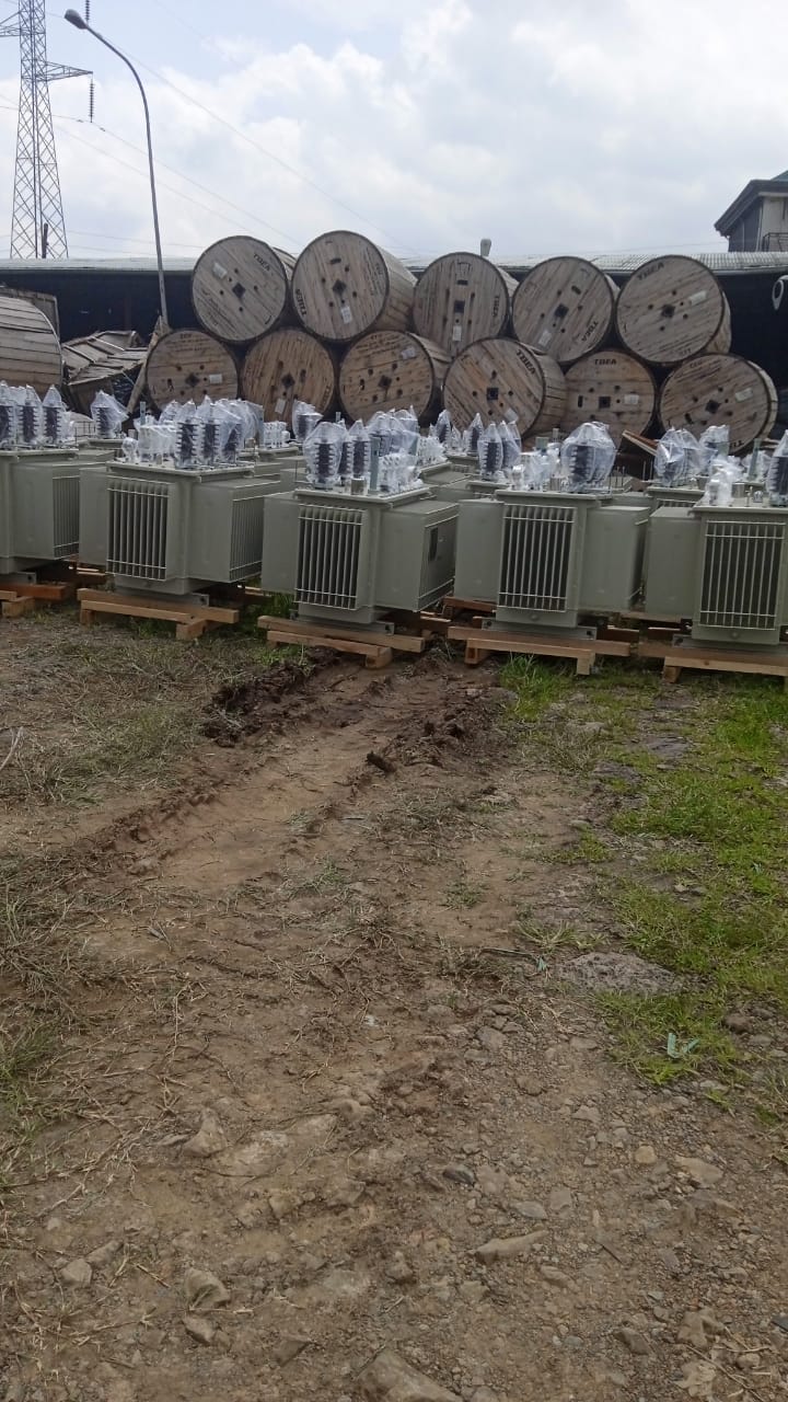 Power transformers staged securely next to massive wooden cable spools in Ethiopia
